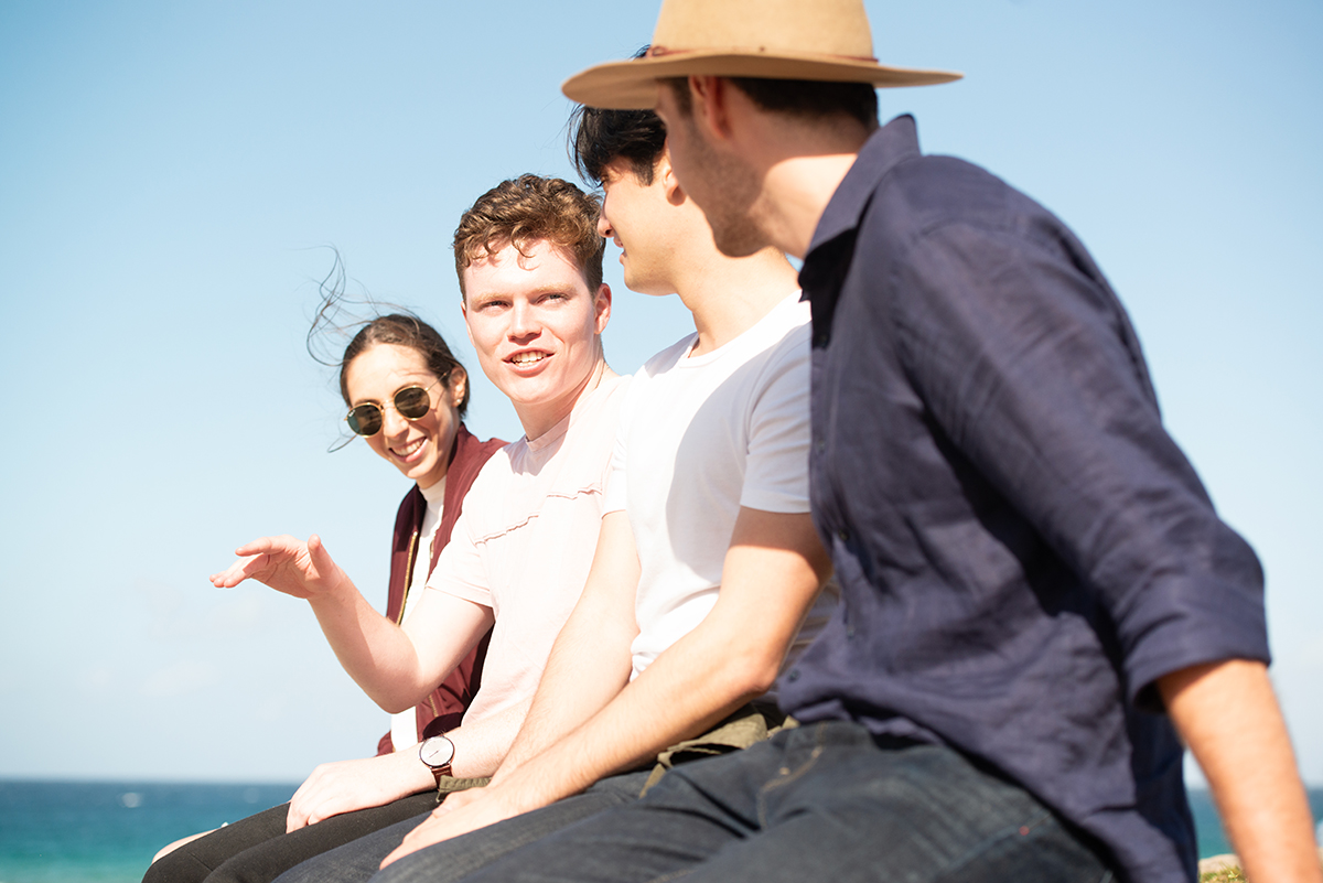 A group of young people laughing together running up a hill