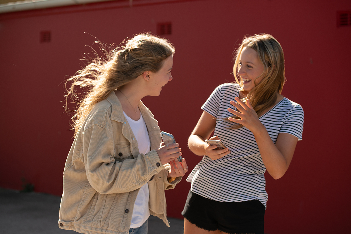 Two teenagers walking and talking to each other