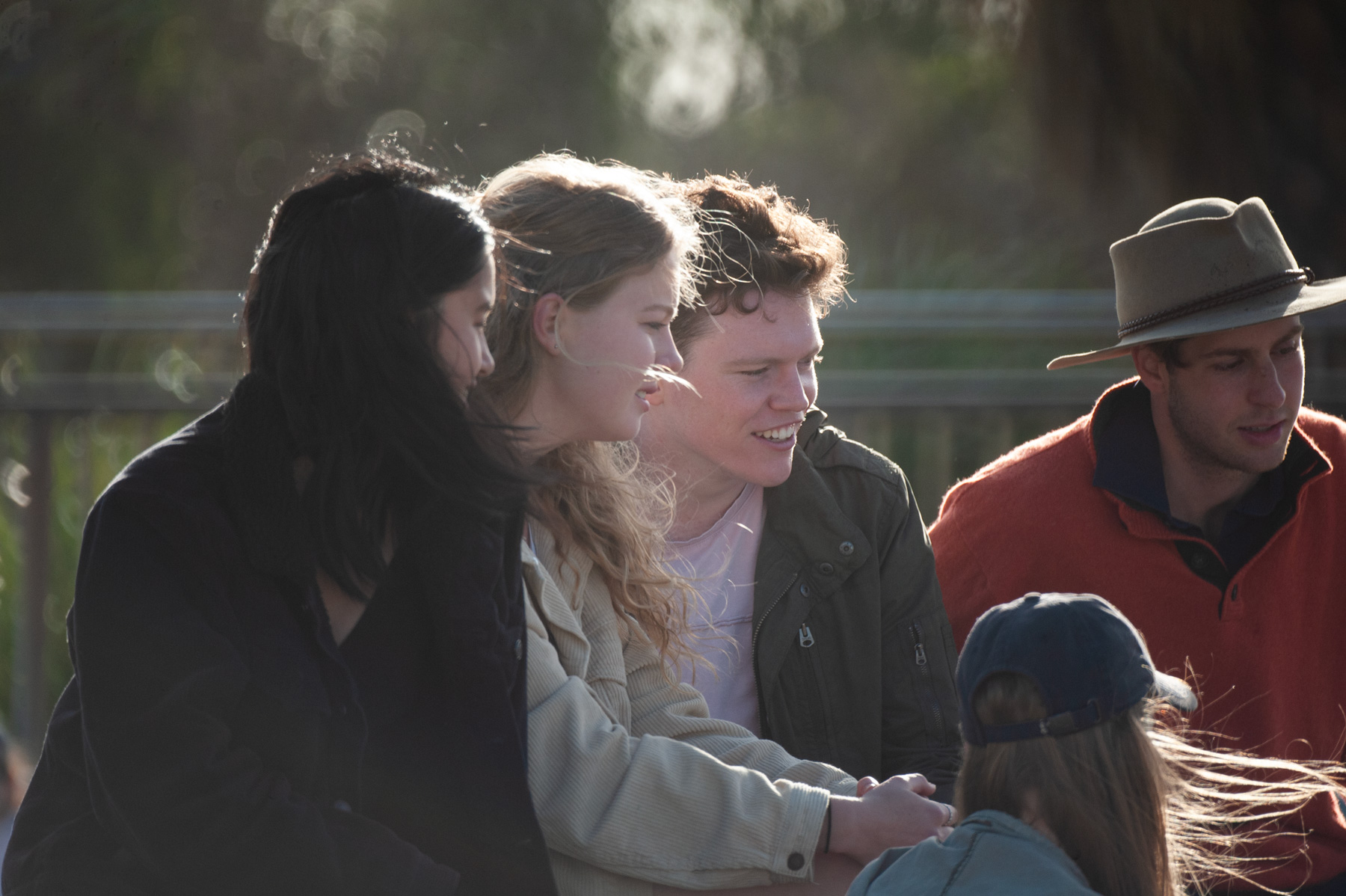 A group of young people laughing together running up a hill